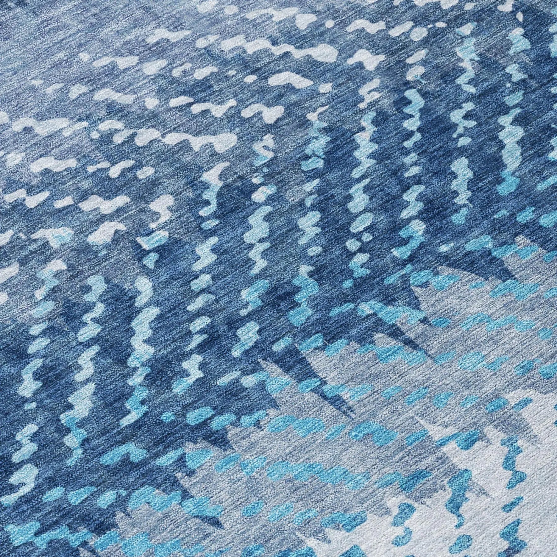 Modern blue abstract-patterned area rug in varying shades of blue and light gray, crafted from soft, durable material.