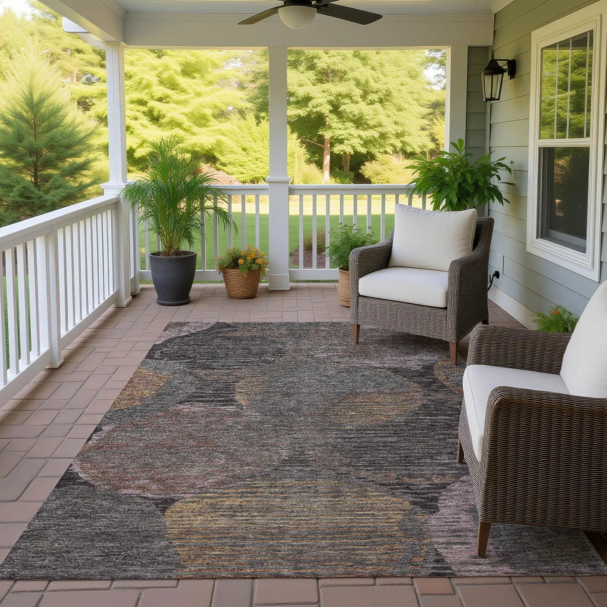 Gray and brown abstract outdoor rug on a patio, complementing wicker chairs and greenery.