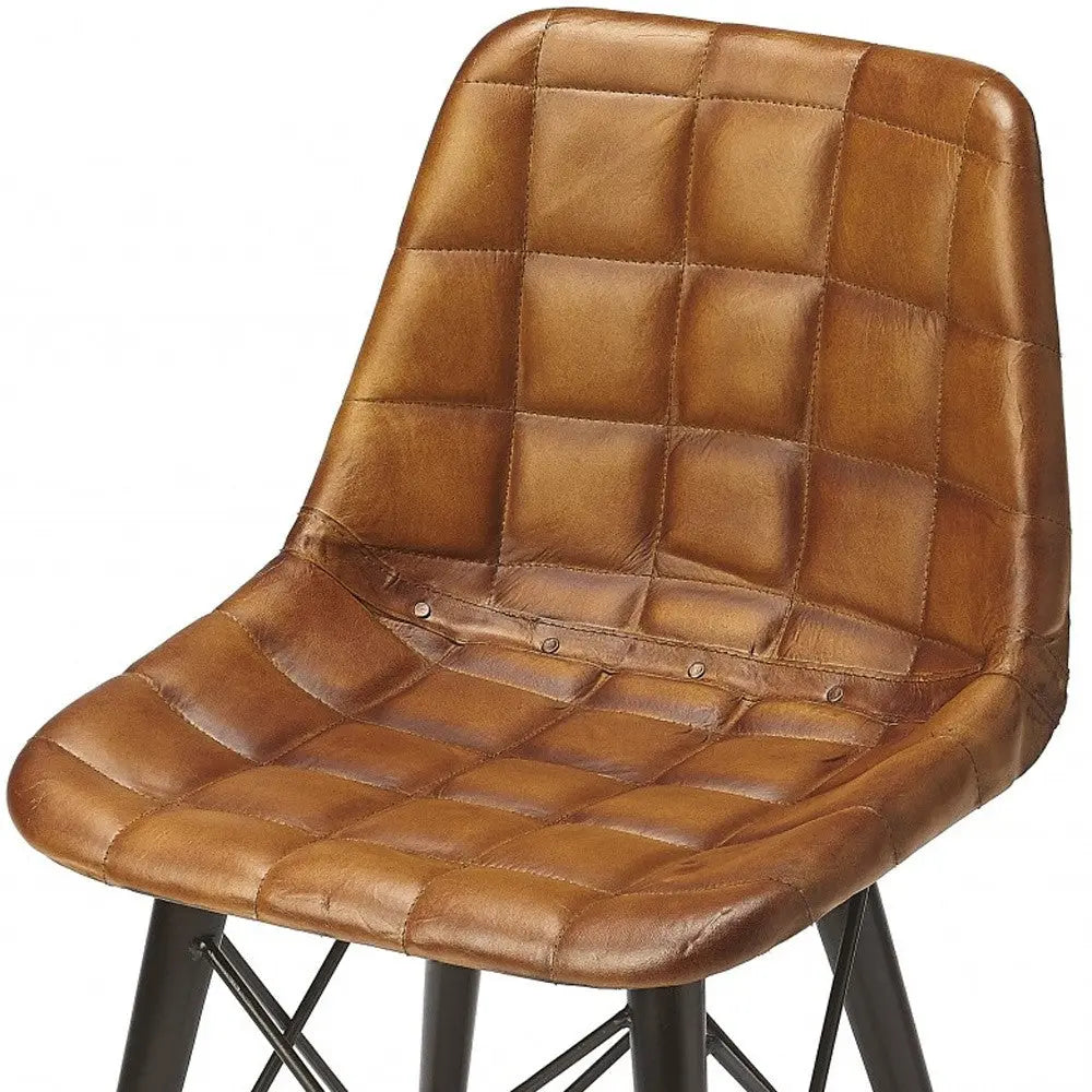 Brown quilted leather dining chair with black metal legs, showcasing a contemporary industrial style.