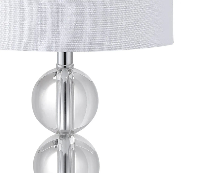 Clear crystal table lamp with white linen shade, modern design, perfect for contemporary home decor.