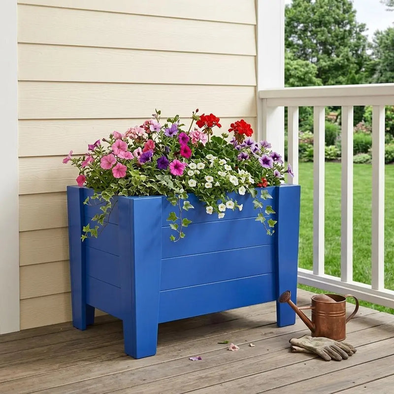Vibrant blue wooden planter box filled with colorful petunias and ivy, perfect for outdoor gardening.
