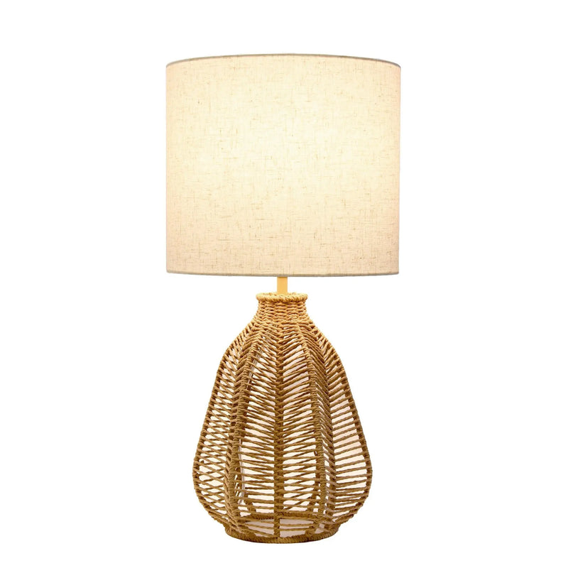 Natural woven rattan table lamp with a cream linen drum shade, perfect for a boho-chic home decor.