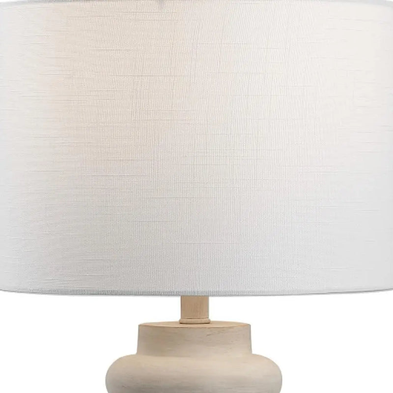 White textured lampshade on a sleek wooden base, perfect for modern home decor.