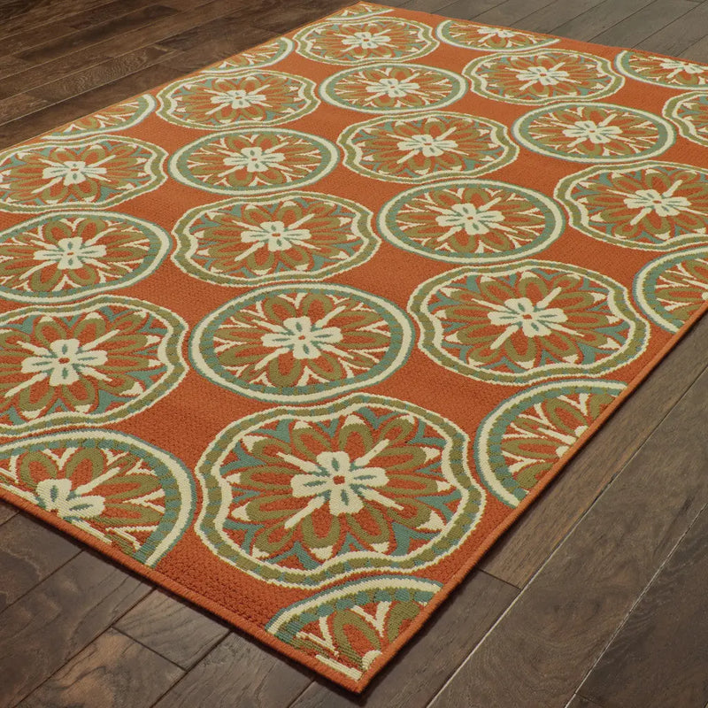 Vibrant orange area rug with floral medallion pattern in blue and cream, ideal for boho-chic home decor.