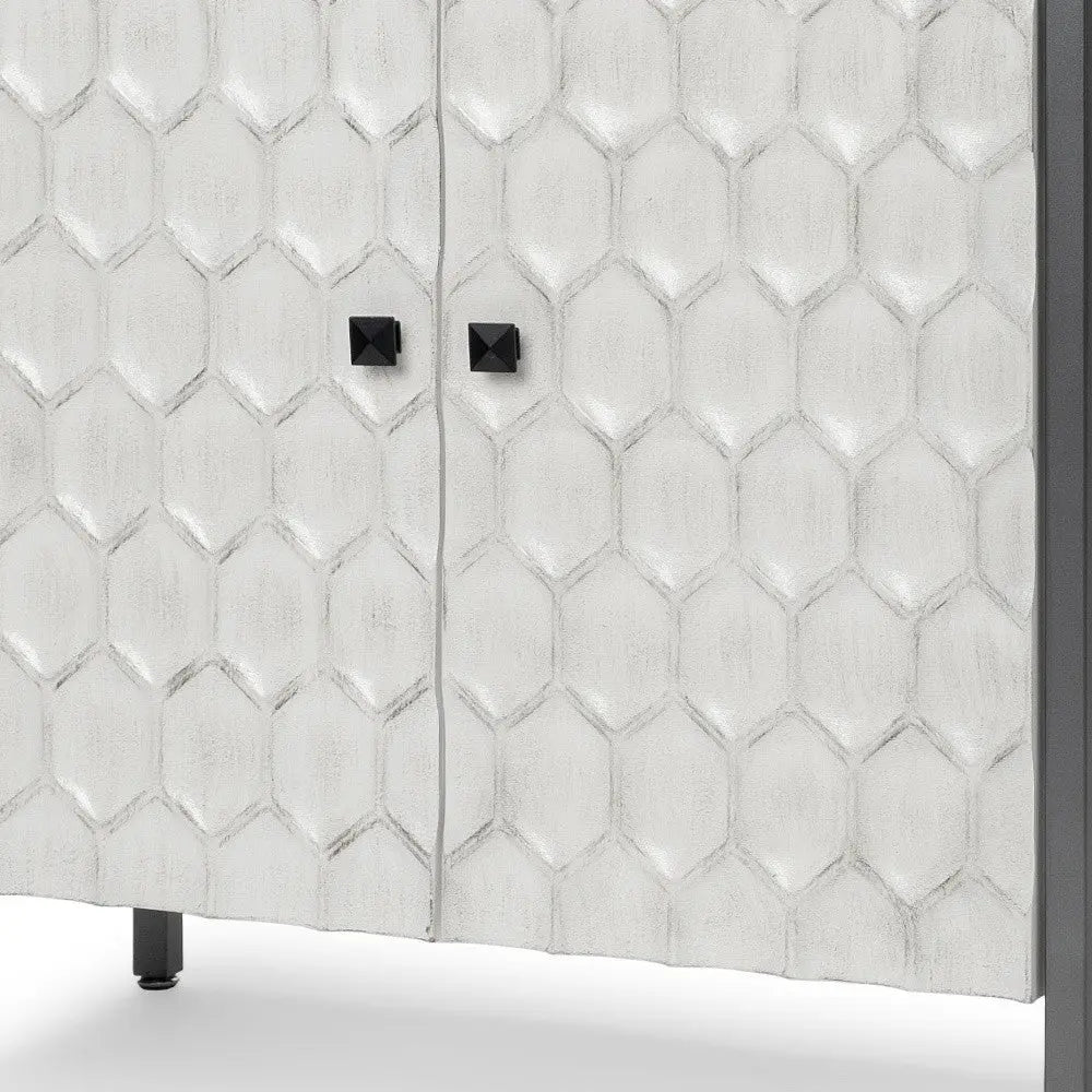 White honeycomb-patterned cabinet with black cube handles and a sleek metal frame. Perfect for modern decor.