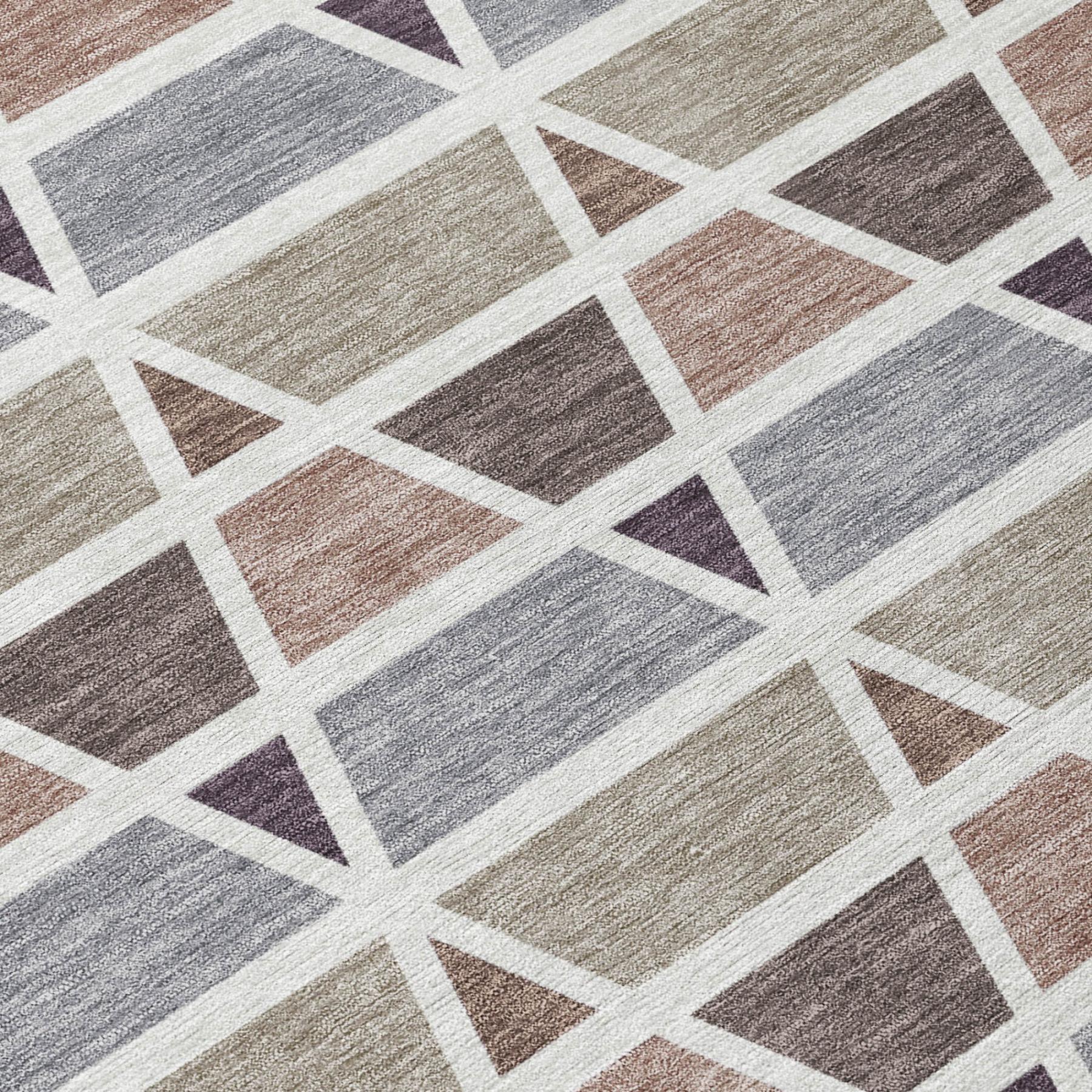 Geometric area rug in soft pastels of pink, gray, and beige, featuring a modern, woven design on a neutral background.