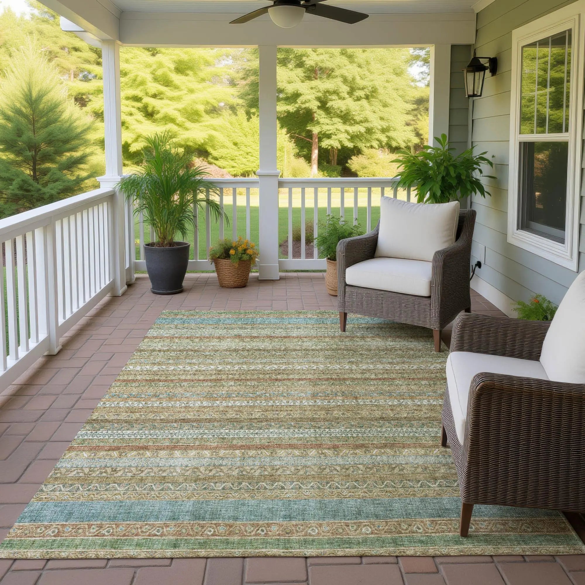 Light blue and beige striped outdoor area rug on a patio, featuring a decorative design, perfect for enhancing outdoor spaces.