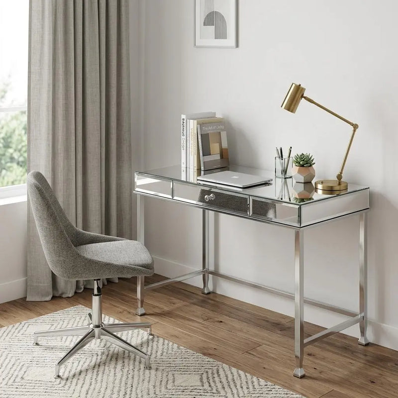 Stylish mirrored desk with silver metal legs, glass top, and a single drawer, paired with a gray upholstered swivel chair.