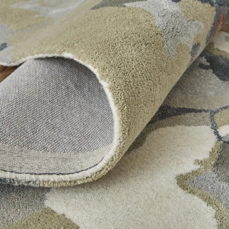 Soft, plush green and beige floral rug with a grey backing, perfect for modern or rustic home decor.