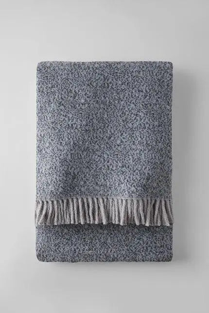 Soft blue knitted throw blanket with grey fringe detail, perfect for cozying up in style.