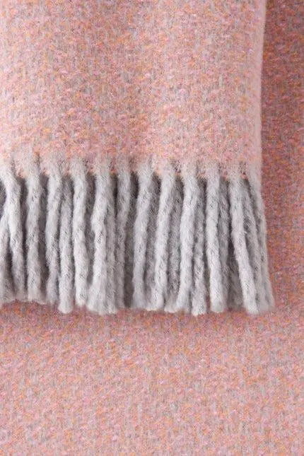 Soft pink and gray fringed wool scarf, perfect for cozy layering in chilly weather.