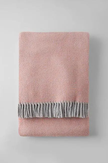 Soft pink blanket with a cozy gray fringed trim, perfect for adding warmth and style to any room.