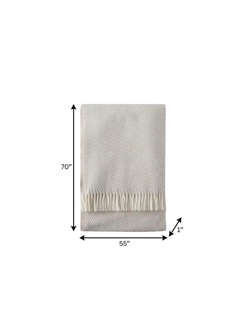 Cream woven blanket with fringe edges, 70"x55", perfect for cozying up on chilly evenings.
