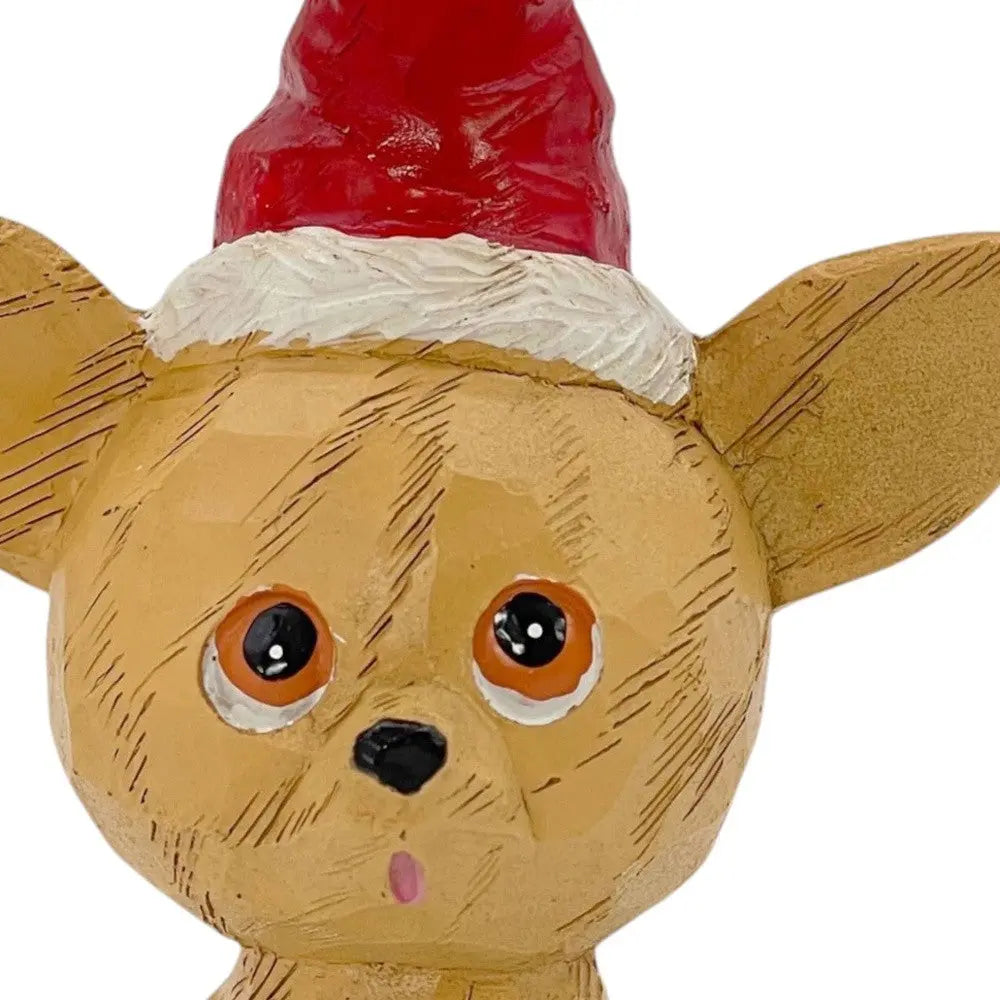 Ceramic Christmas dog figurine in tan with a red Santa hat, featuring hand-painted details and a whimsical design.