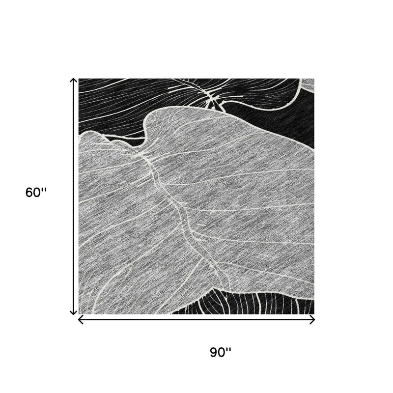Black and white abstract leaf print rug, 90"x60", soft fiber material, modern style for contemporary decor.