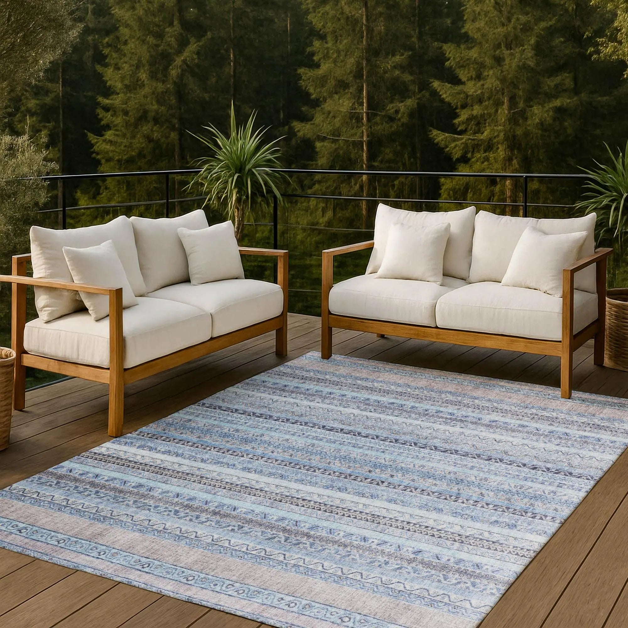 Light blue patterned area rug paired with natural wood modern outdoor sofas, featuring plush white cushions.