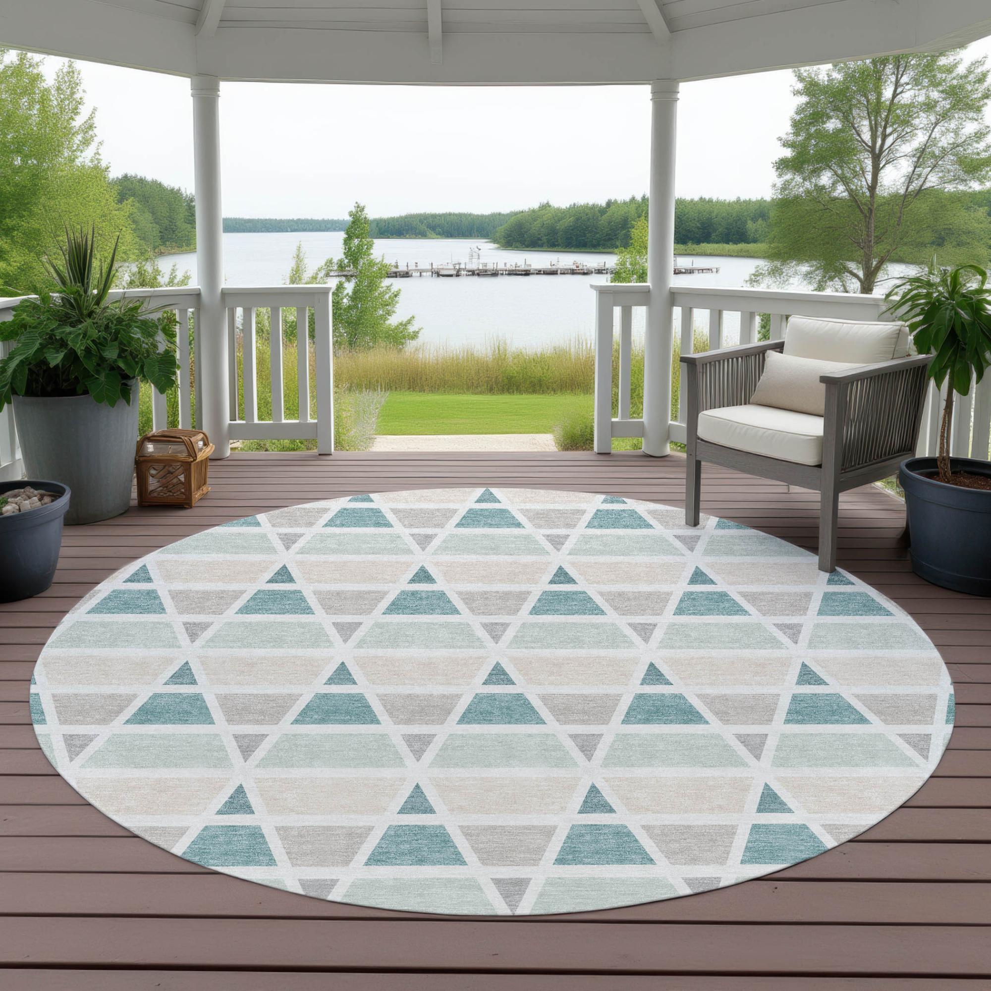 Round geometric area rug with teal, gray, and white triangles, perfect for outdoor use on porch or patio.