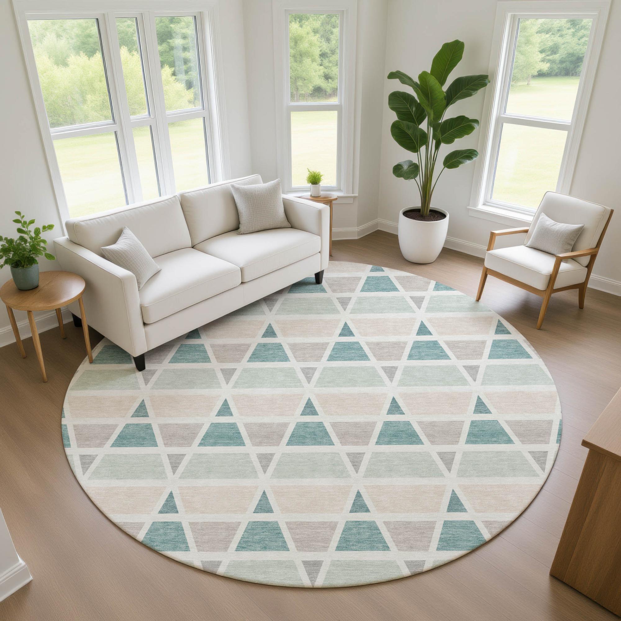 Round geometric area rug featuring teal, beige, and cream triangles, perfect for modern living spaces.