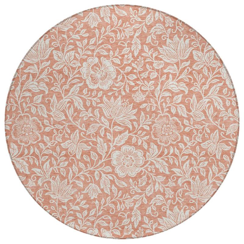 Round floral area rug in coral pink with white botanical patterns, perfect for adding a touch of elegance to any space.