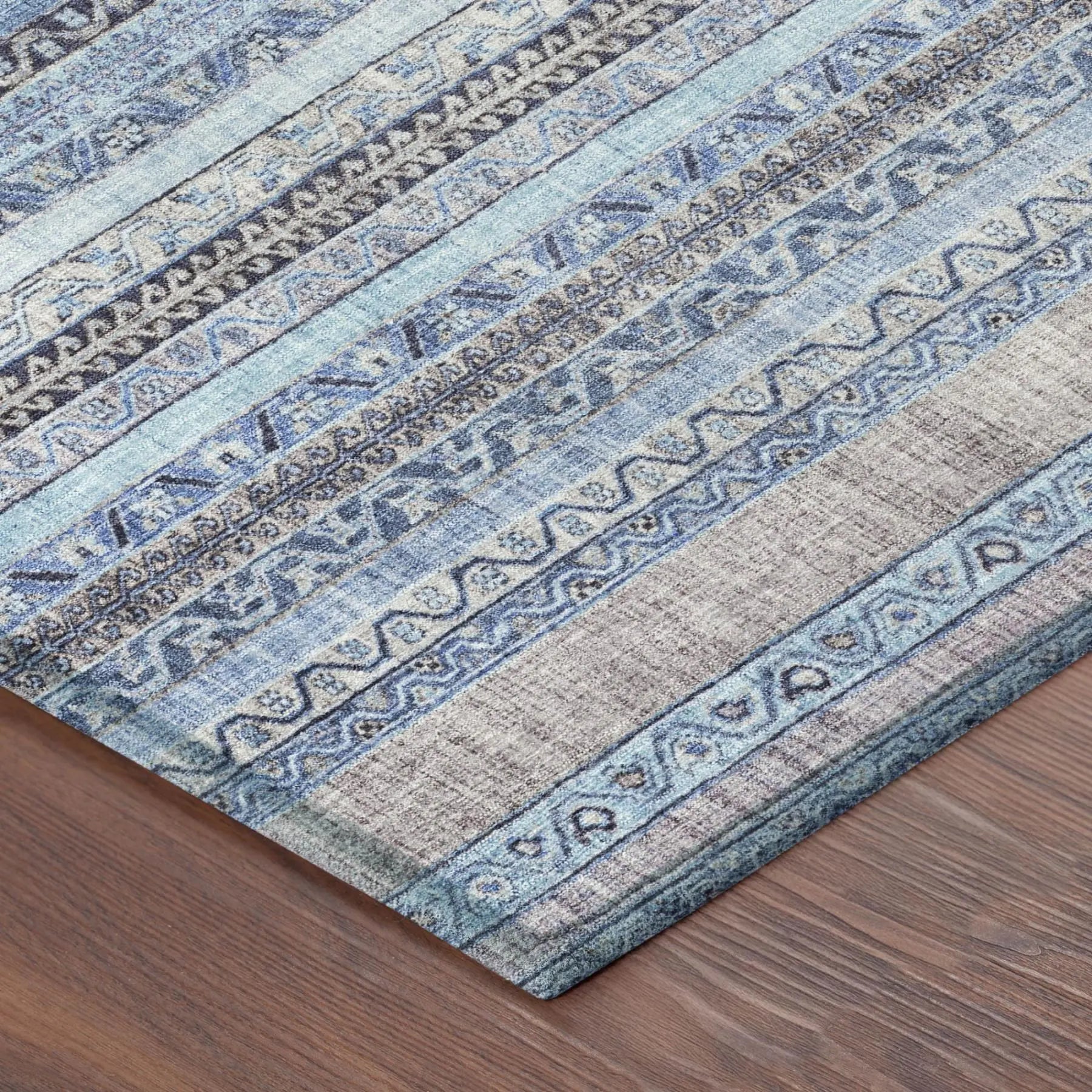 Blue patterned area rug in soft wool blend, featuring intricate tribal designs and a modern, layered texture.