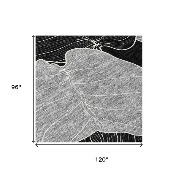 Black and white abstract leaf pattern area rug, 120"x96", made of durable synthetic fibers for modern decor.