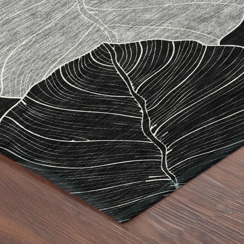 Black and white leaf-patterned area rug, crafted from durable synthetic fibers, adds modern elegance to any space.