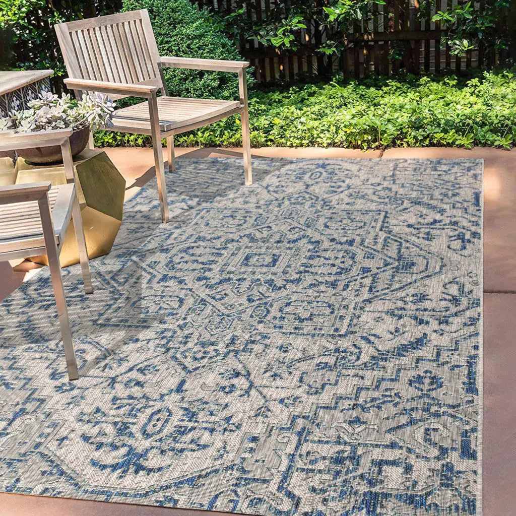 Blue and beige outdoor area rug featuring intricate patterns, perfect for patios and gardens. Durable material.