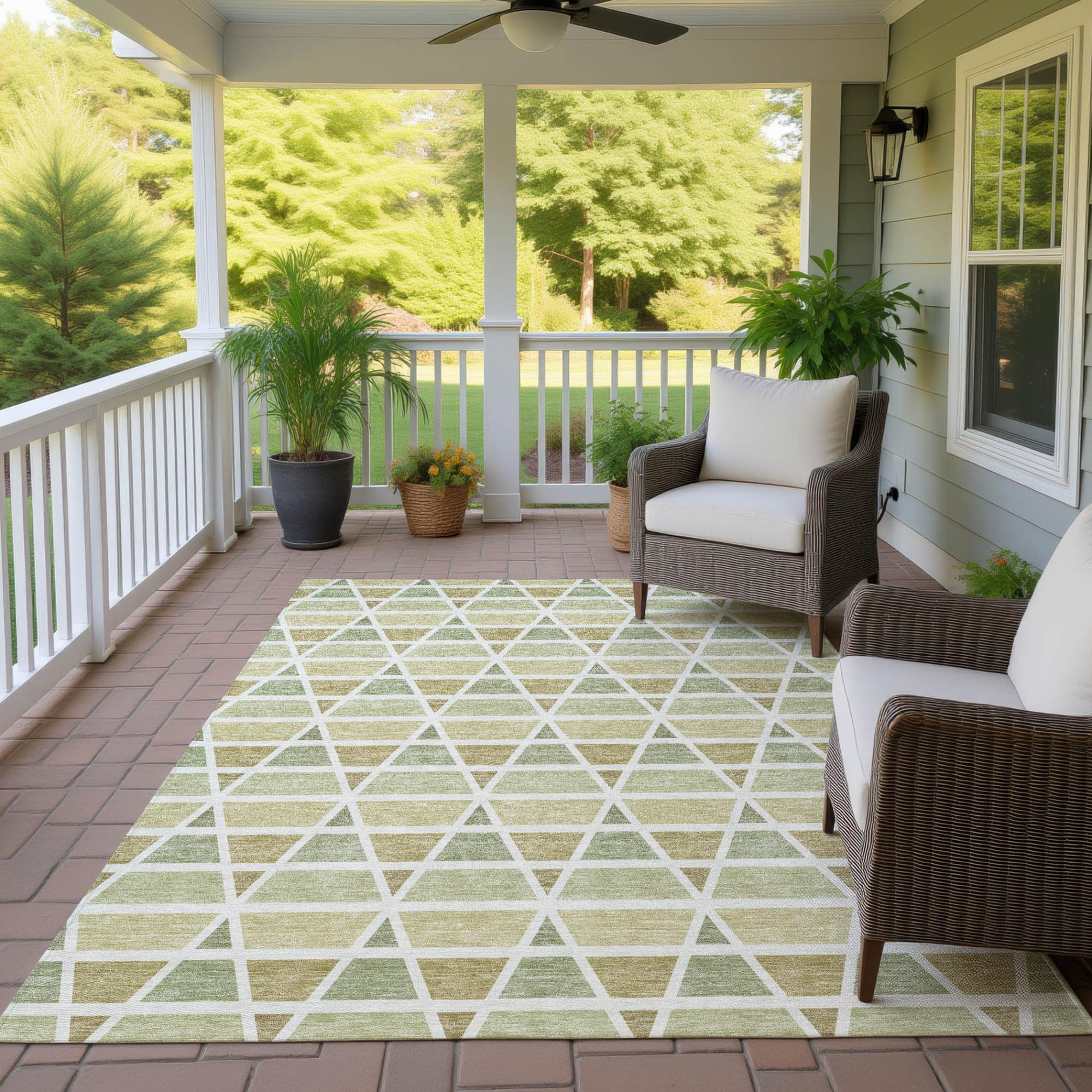 Green and cream geometric outdoor area rug on a porch, complementing a modern, cozy seating arrangement.