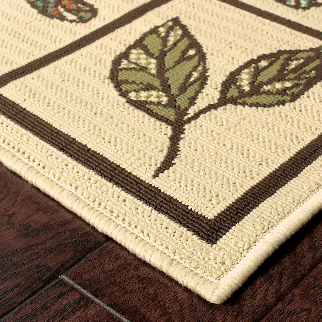 Beige woven area rug with leaf patterns and a brown border, perfect for home decor.