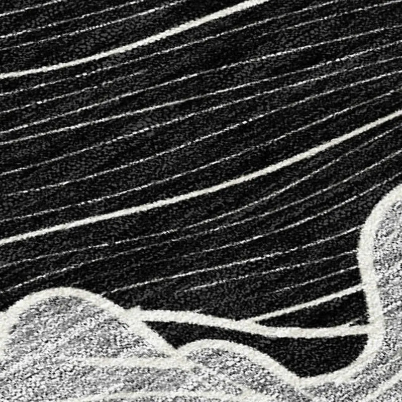 Black and white abstract area rug, made from soft yarn, featuring flowing lines and wave patterns for modern decor.