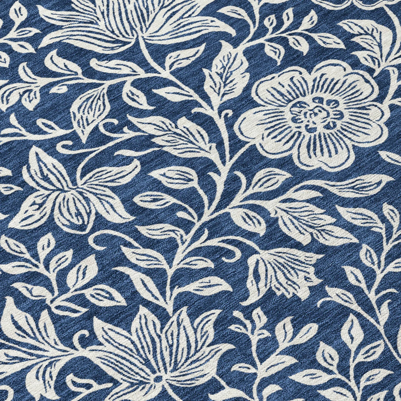 Navy blue floral area rug with white embroidered flowers and leaves, perfect for modern or bohemian home decor.