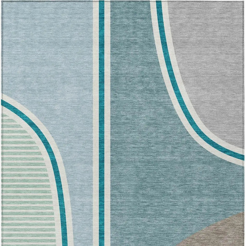 Abstract geometric area rug in blue, teal, and gray hues, featuring a soft wool blend texture for modern decor.