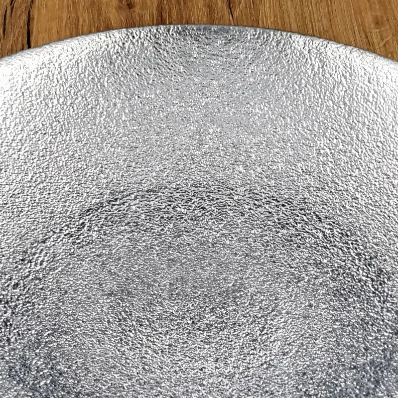 Silver textured serving platter on a wooden surface, perfect for modern dining decor.