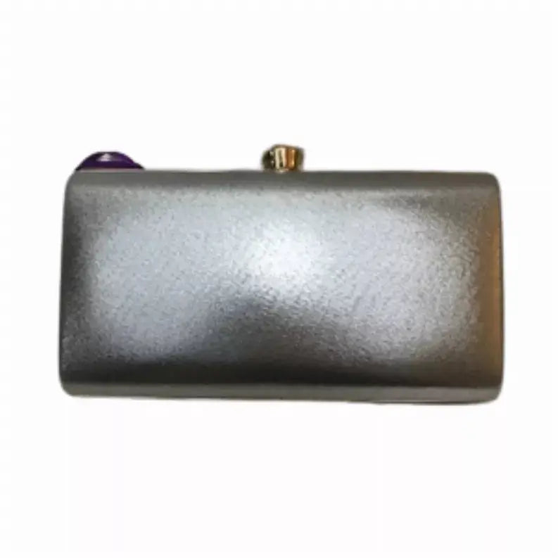 Silver metallic clutch purse with jewel accent, sleek rectangular design, perfect for evening events.