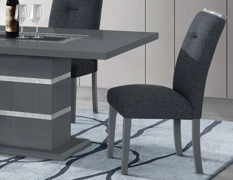 Modern gray upholstered dining chair with sleek wooden legs and subtle glitter accents, set against a stylish rug.