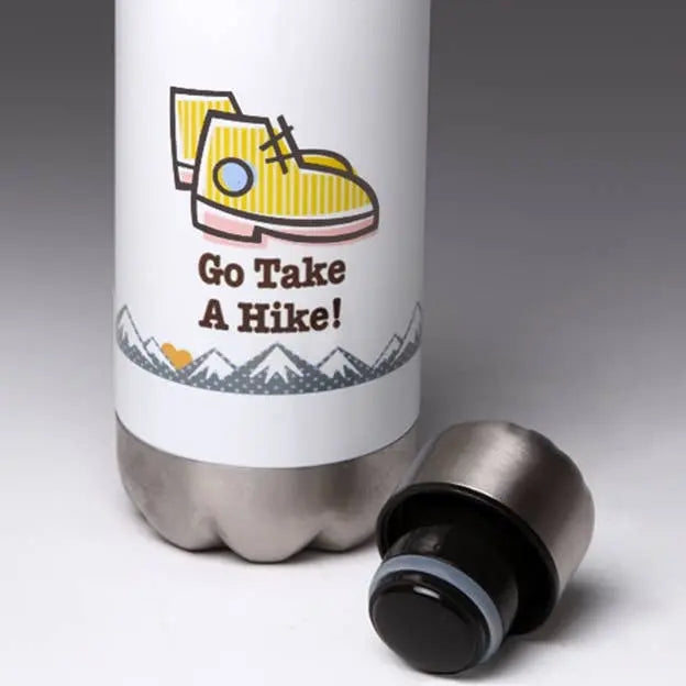 White stainless steel water bottle with yellow hiking boots graphic and "Go Take A Hike!" text, featuring a black lid.