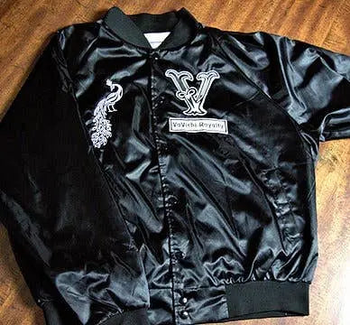Black satin bomber jacket with embroidered logo and peacock design, stylish and trendy for a modern look.