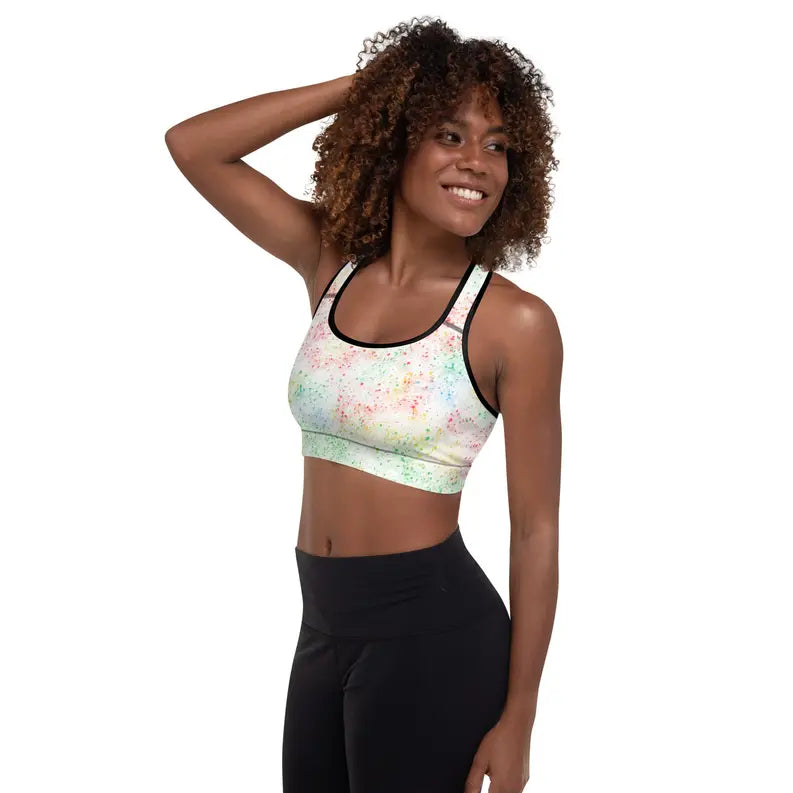 Multicolor splatter print sports bra with black trim, made from breathable fabric, perfect for workouts and casual wear.