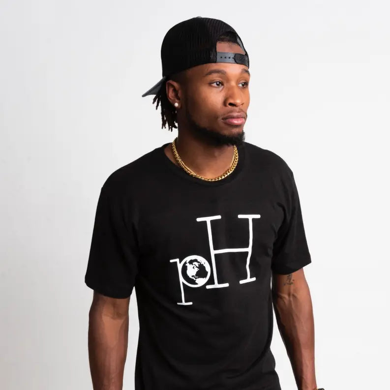 Men's black cotton t-shirt with white globe logo, paired with a black snapback and gold chain. Stylish and casual.
